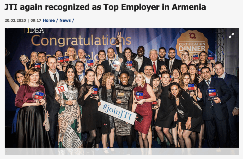 A picture of JTI employees smiling with TEI badges and a large "joinJTI" sign.